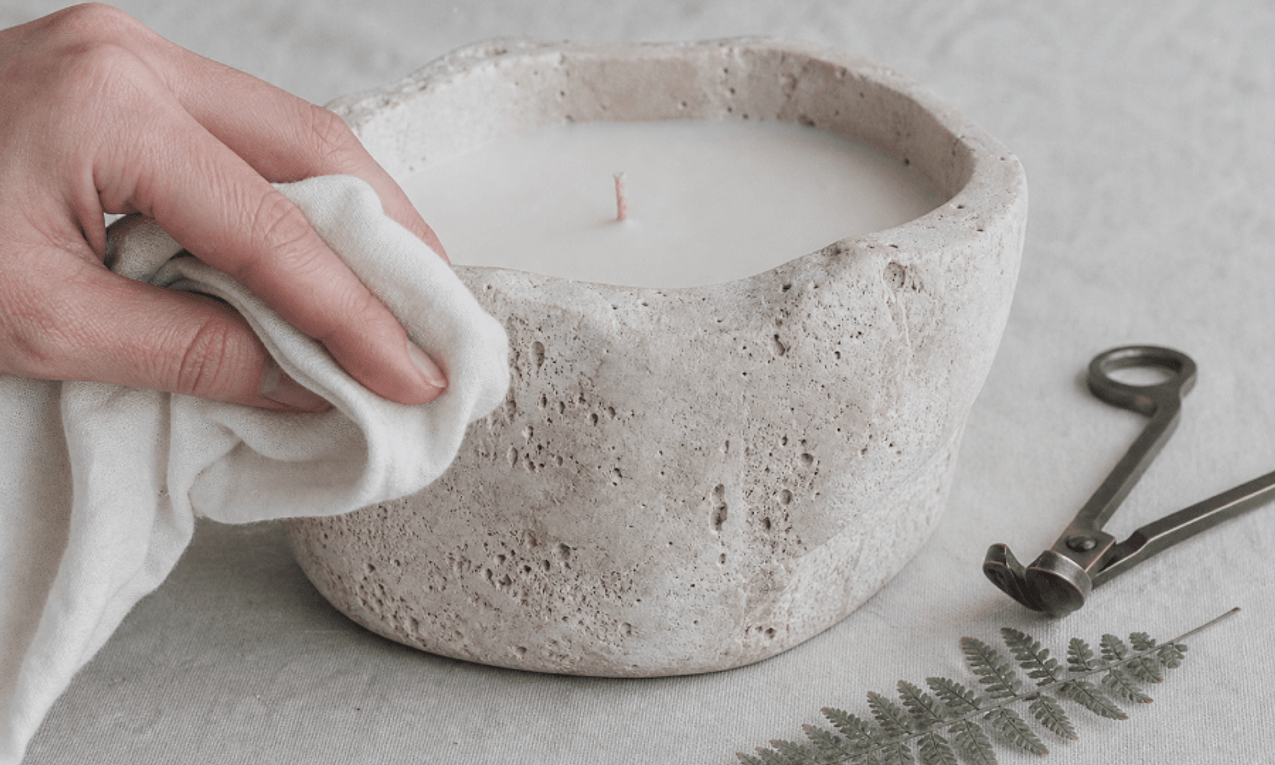 A stone candle being wiped gently with a soft cloth