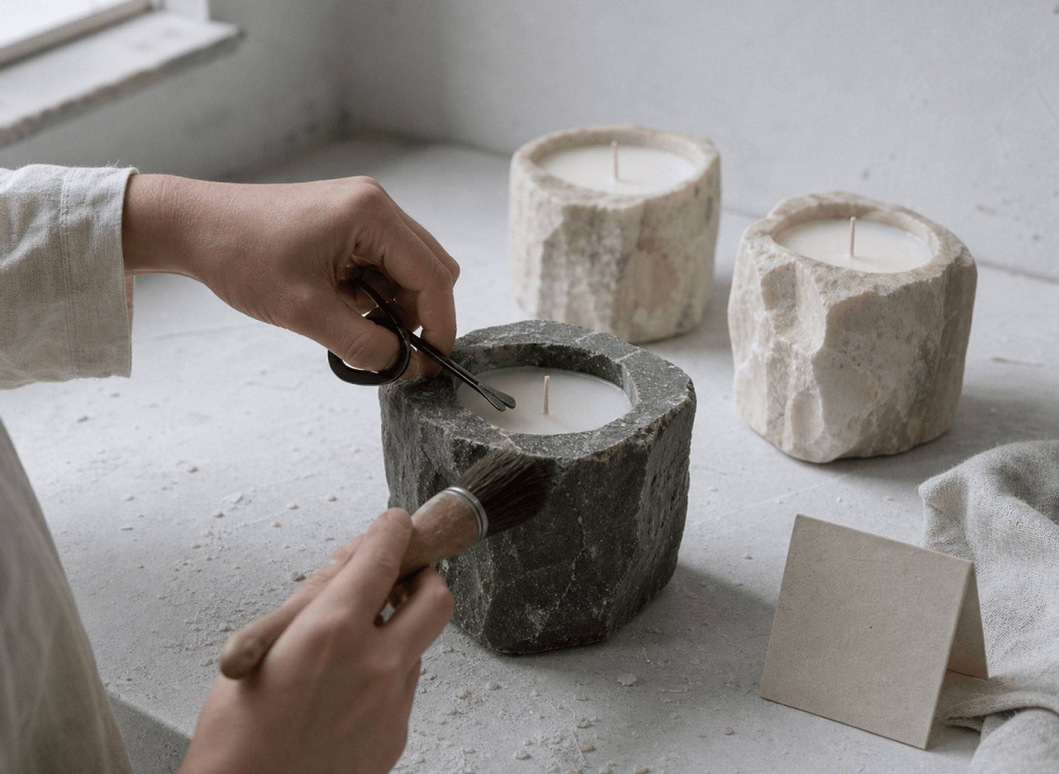 A dark stone candle receiving its final inspection